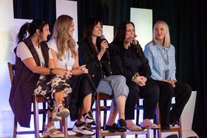 Chelle speaking on stage with other salon mentors at HPSA.